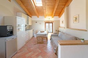 a kitchen and living room with a couch and a table at Agriturismo Corte Albarel in Castelnuovo del Garda