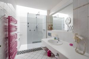 bagno bianco con lavandino e doccia di Appartementhaus Mecklenburg a Kühlungsborn