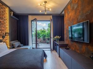 a bedroom with a bed and a tv on a wall at Loft House Premium Apartments in Wrocław