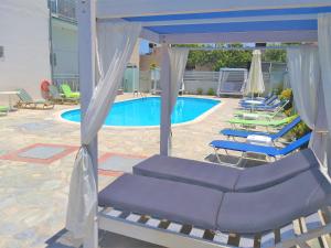 a group of lounge chairs in front of a pool at Sun Boutique Hotel (Adults Only) in Amoudara Herakliou