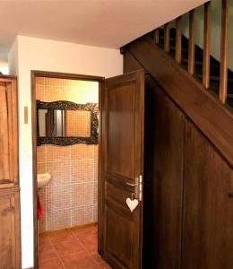 a bathroom with a wooden door with a staircase at Casa Adosada en Santa Leocadia in Sainte-Léocadie