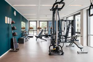 a gym with several tread machines in a room with blue walls at Amsterdam ID Aparthotel in Amsterdam
