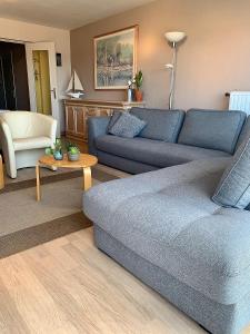 a living room with a blue couch and a table at Beach View Five in Blankenberge