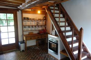 cocina con escalera y fogones en una habitación en Le cottage du Coudray, gîte avec chalet sauna, 