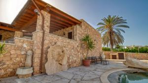 a house with a stone wall and a swimming pool at Residence Il Corallo - Guitgia in Lampedusa
