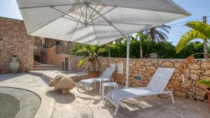 a patio with two chairs and an umbrella at Residence Il Corallo - Guitgia in Lampedusa