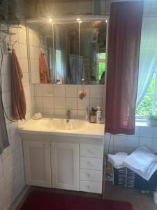 y baño con lavabo y espejo. en Egen stuga med delat badrum, en Norrtälje