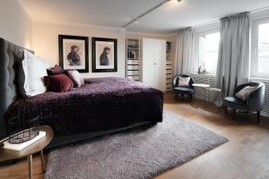 a bedroom with a bed and a chair and windows at SAXX Apartments Hagen in Hagen