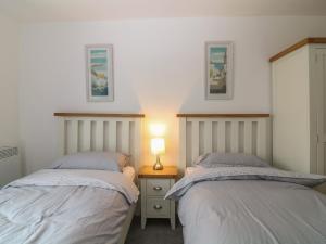 帕爾的住宿－Lowena，一间卧室配有两张床和床头灯。