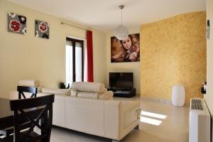 a living room with a white couch and a tv at Alla Dimora di Chiara Apartment in Matera
