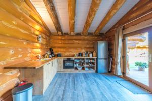 a kitchen in a log cabin with a refrigerator at Ferienidyll zur Spreeaue in Briesen