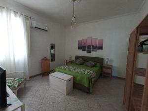 een slaapkamer met een groen bed in een kamer bij Casa Vacanze Ni Nuccia in Trapani