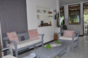 sala de estar con 2 sillas y mesa en Guesthouse The 4 Fish en Manado
