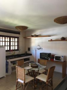 a kitchen with a table and chairs in a kitchen at Cond Residencial Resort Pipa Chalés Triplex - Centro de Pipa in Pipa