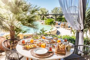 a table with food and drinks on a patio at Alacatı Port Ladera Hotel - Adult Only in Alaçatı