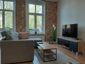 ein Wohnzimmer mit einem Sofa und einem TV in der Unterkunft Apartamenty Lubin - Loft in Lubin