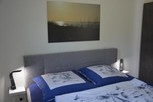 a bedroom with a bed with blue and white pillows at Ostsee-Karo in Graal-Müritz