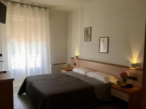 a bedroom with a bed and a window with lights at Hotel Trieste in San Giórgio di Nogaro