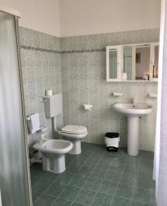 a bathroom with two toilets and a sink at Hotel Trieste in San Giórgio di Nogaro