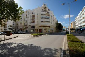 una calle vacía frente a un gran edificio en Casa Nau B, en Armação de Pêra