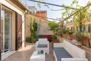 an outdoor patio with white furniture and plants at Monti Stairway to Heaven in Rome