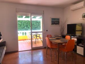 ein Wohnzimmer mit einem Tisch und Stühlen sowie eine Terrasse in der Unterkunft Aunt Antonia Beach House in Málaga