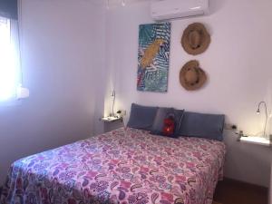 1 dormitorio con 1 cama con manta morada en Aunt Antonia Beach House, en Málaga