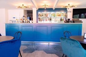 a blue bar with two tables and chairs at Dworek Bursztynowy in Karwia