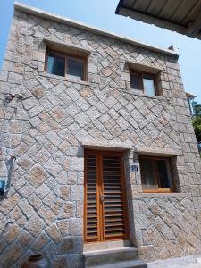 kamienny budynek z drzwiami i trzema oknami w obiekcie Jinsha Haiyunbian I Homestay w mieście Nangan