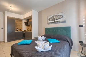 ein Schlafzimmer mit einem Bett mit blauen Kissen und eine Küche in der Unterkunft Adriatic Apartments Fažana in Fažana