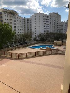 a swimming pool in a city with tall buildings at Casa Nau B in Armação de Pêra