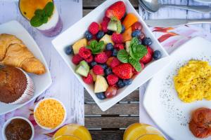 a table topped with a plate of fruit and vegetables at 4 on Varneys Guest House in Cape Town