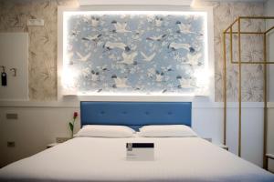 Bett mit blauem Kopfteil in einem Zimmer in der Unterkunft Hotel Palace in Battipaglia
