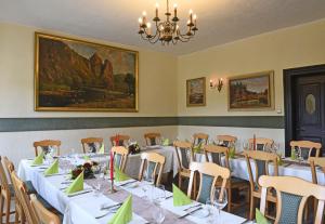 a dining room with tables and chairs and a chandelier at Weinhaus Hehner-Kiltz in Waldböckelheim