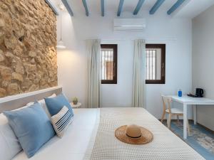 ein Schlafzimmer mit einem weißen Bett mit blauen Kissen in der Unterkunft Hostal Altea House in Altea