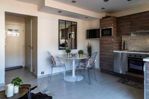 - une cuisine et une salle à manger avec une table et des chaises dans l'établissement Le Deauvilla - Duplex Penthouse vue mer Deauville, à Deauville