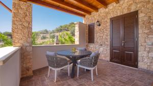 a patio with a table and chairs and a window at Residence Il Corallo - Guitgia in Lampedusa
