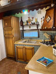 - une cuisine avec des placards en bois et un évier dans l'établissement A casa di Eugenio, à Carini