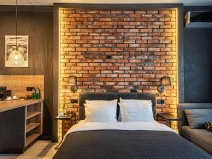 a bedroom with a bed and a brick wall at Loft House Premium Apartments in Wrocław