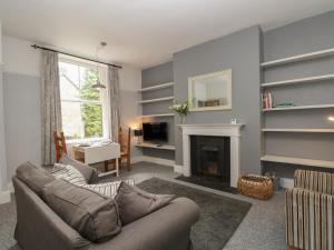 ein Wohnzimmer mit einem Sofa und einem Kamin in der Unterkunft Belvedere in Buxton