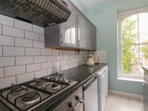 eine Küche mit einem Herd oberer Ofen neben einem Fenster in der Unterkunft Belvedere in Buxton