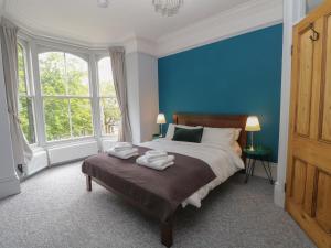 a blue bedroom with a bed with towels on it at Belvedere in Buxton