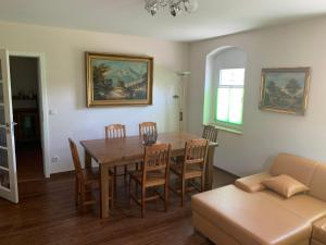 a dining room with a table and chairs and a couch at Im Ballhaus Neuhilbersdorf in Chemnitz