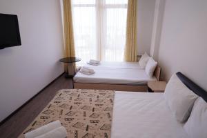 アドレルにあるPapaya Hotelのベッド2台と窓が備わる小さな客室です。