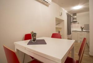 a white table with red chairs and a vase on it at Apartment Matteotti 199 in Rovinj