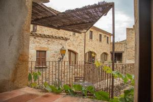 an outside view of a stone building with a gate at Can Zoilo Pals in Pals