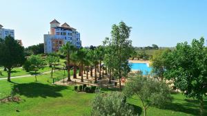 vista su un parco alberato e sulla piscina di Las Marismas by Ĥ a Isla Canela