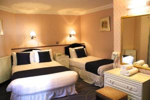 ein Hotelzimmer mit zwei Betten und einem Spiegel in der Unterkunft The Devoncourt Resort in Exmouth