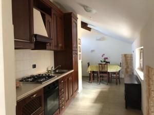 a kitchen with wooden cabinets and a table with a dining room at Residence Les Amis in Castel di Sangro