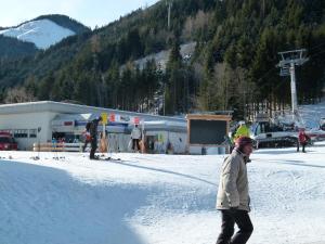 Putterer Stadl في دونيغسباشوالد: رجل يمشي في الثلج أمام نزل للتزلج